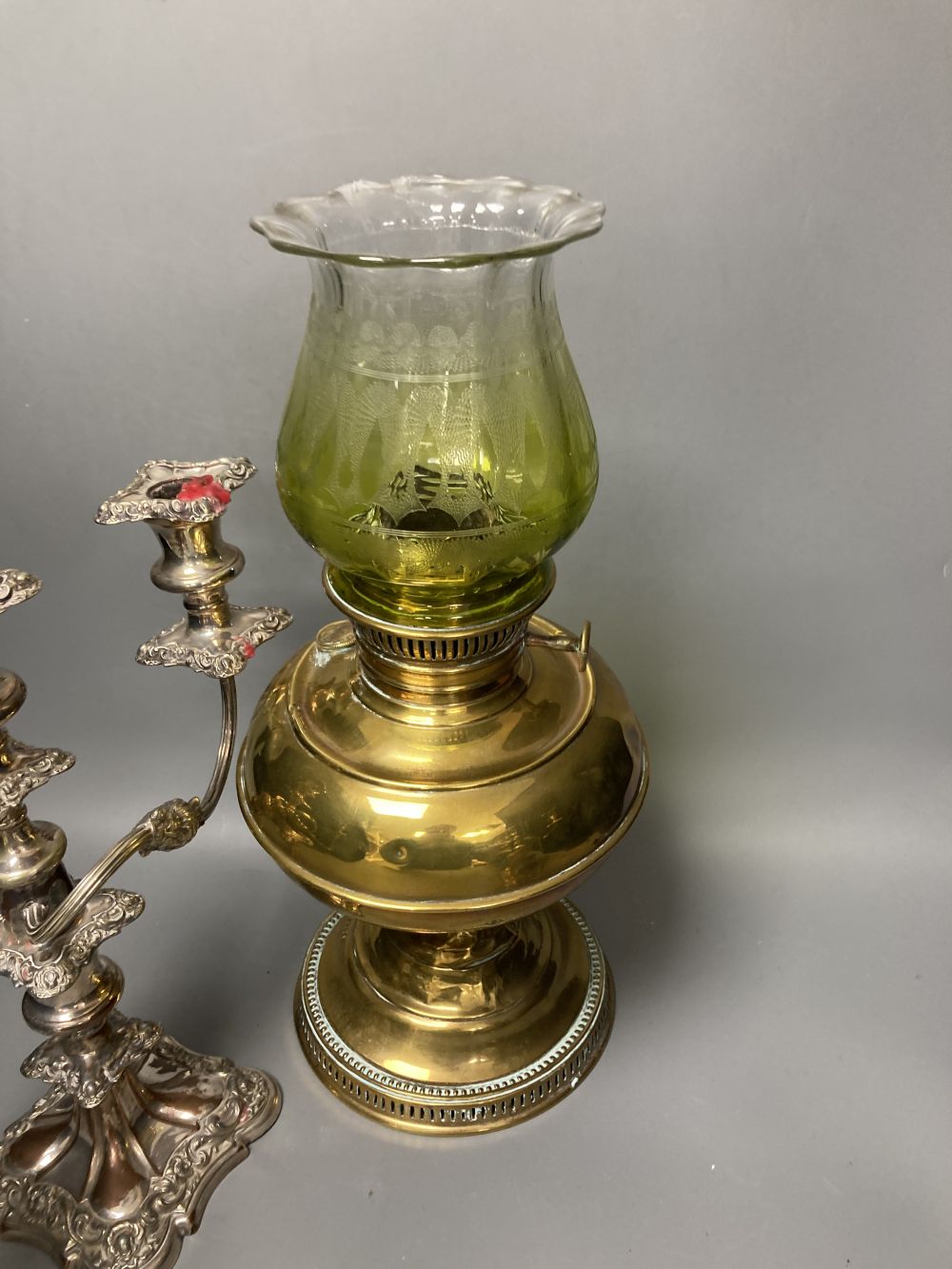 A pair of plated two branch candelabra and a brass oil lamp (3)